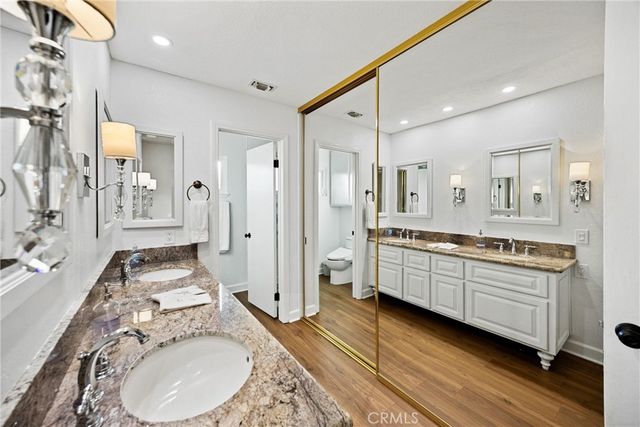 a kitchen with stainless steel appliances granite countertop a dining table chairs refrigerator and microwave