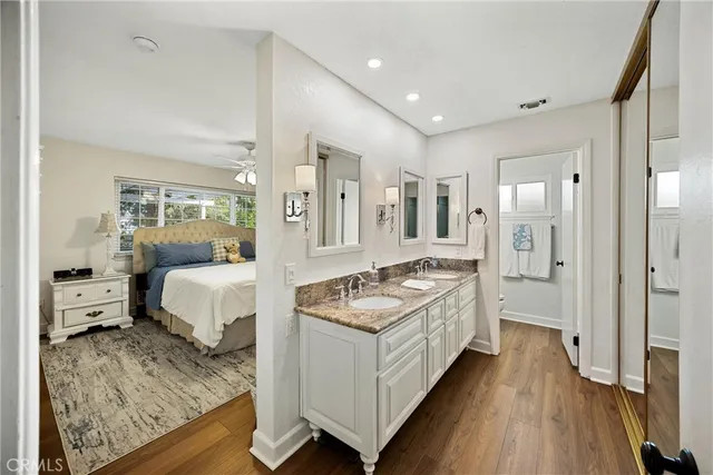 a kitchen with stainless steel appliances granite countertop a table chairs refrigerator and sink