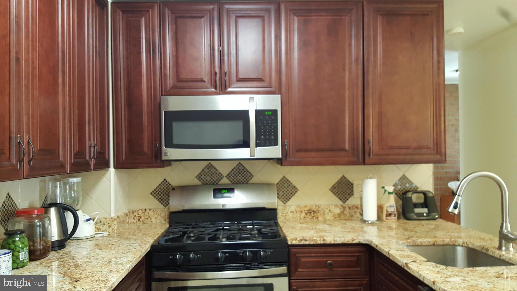 8152 Inverness Ridge Road Potomac, MD 20854 - Photo 6 of 7 a kitchen with granite countertop wood cabinets and stainless steel appliances