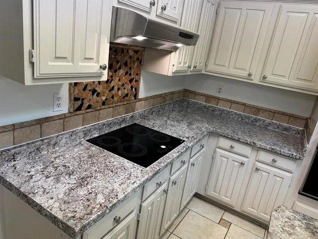 a kitchen with stainless steel appliances granite countertop a sink stove and cabinets