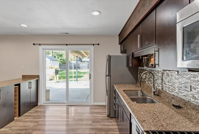 a kitchen with stainless steel appliances granite countertop a sink stove and refrigerator
