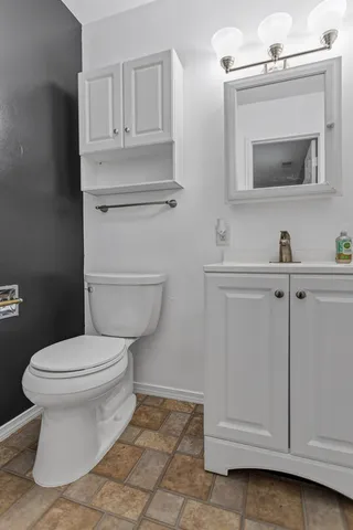 a bathroom with a toilet sink and mirror