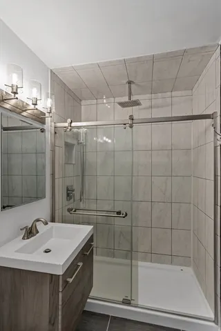 a bathroom with a shower a mirror and a sink