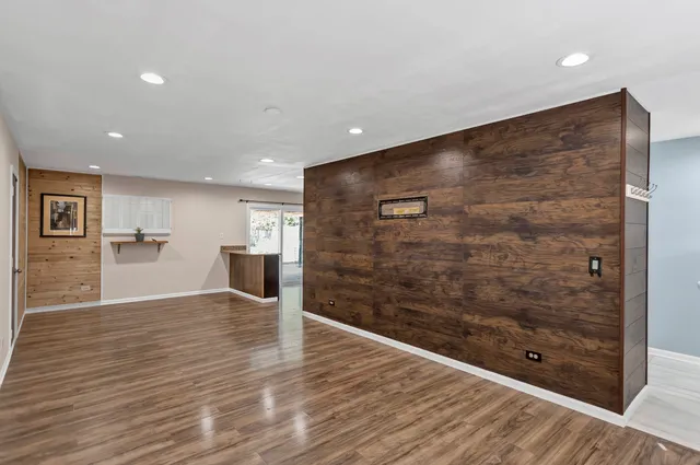 a view of a hallway with wooden floor and fireplace