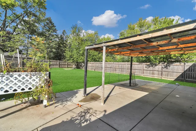 a view of a backyard with wooden fence