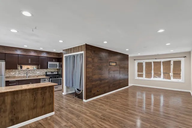 a open kitchen with stainless steel appliances granite countertop a refrigerator and a stove top oven