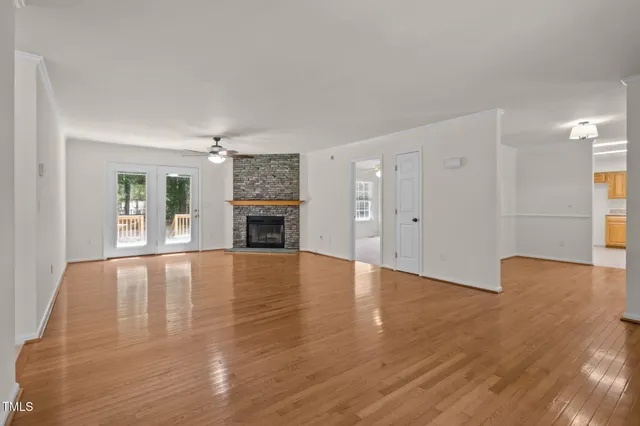 a view of empty room with wooden floor and fireplace