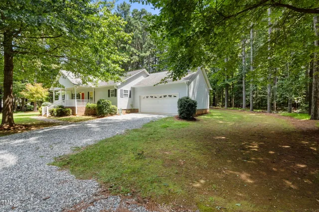 a front view of a house with a yard and trees