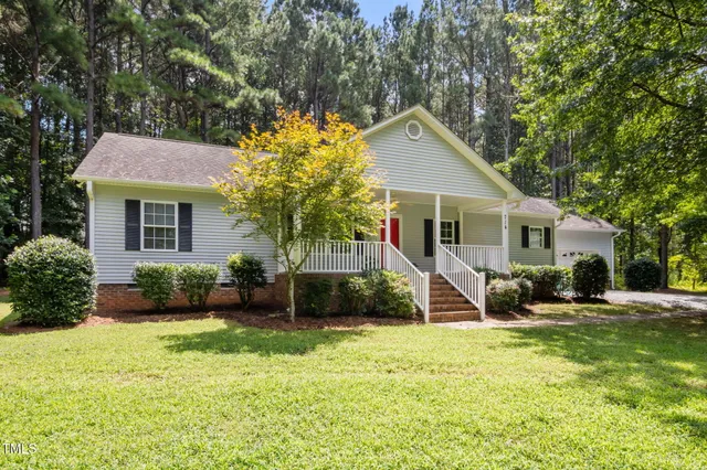 a view of a house with a backyard and a tree
