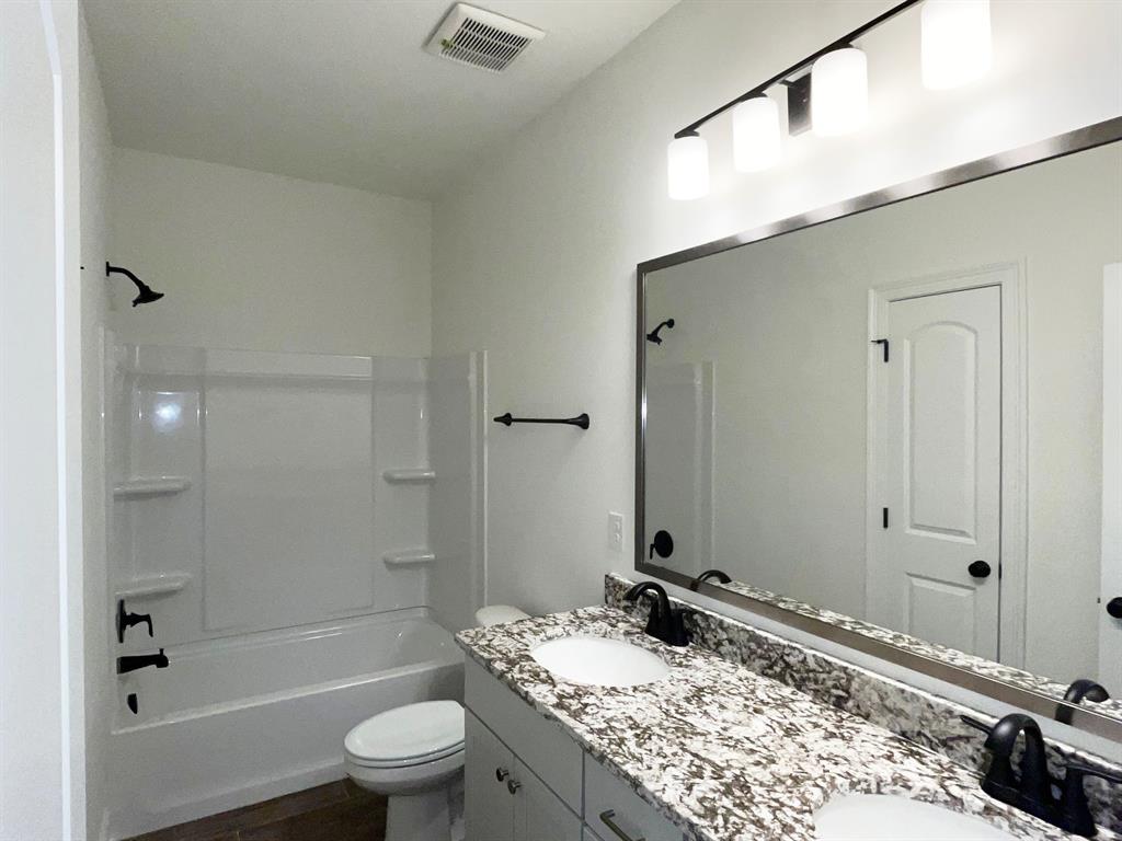 159 Lessie Drive Stonewall, LA 71078 - Photo 25 of 26 a bathroom with a granite countertop sink toilet and shower
