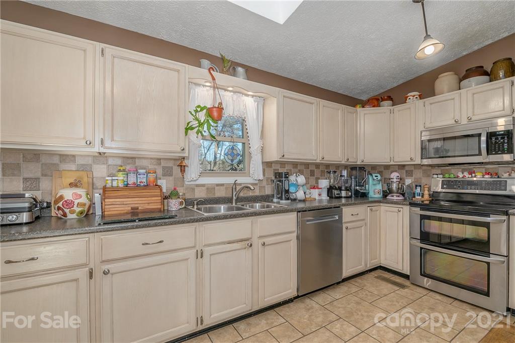 301 Willow Pond Road Rutherfordton, NC 28139 - Photo 19 of 42 a kitchen with kitchen island granite countertop white cabinets white stainless steel appliances and sink