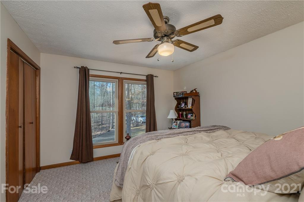 301 Willow Pond Road Rutherfordton, NC 28139 - Photo 30 of 42 a bedroom with a large bed and a chandelier
