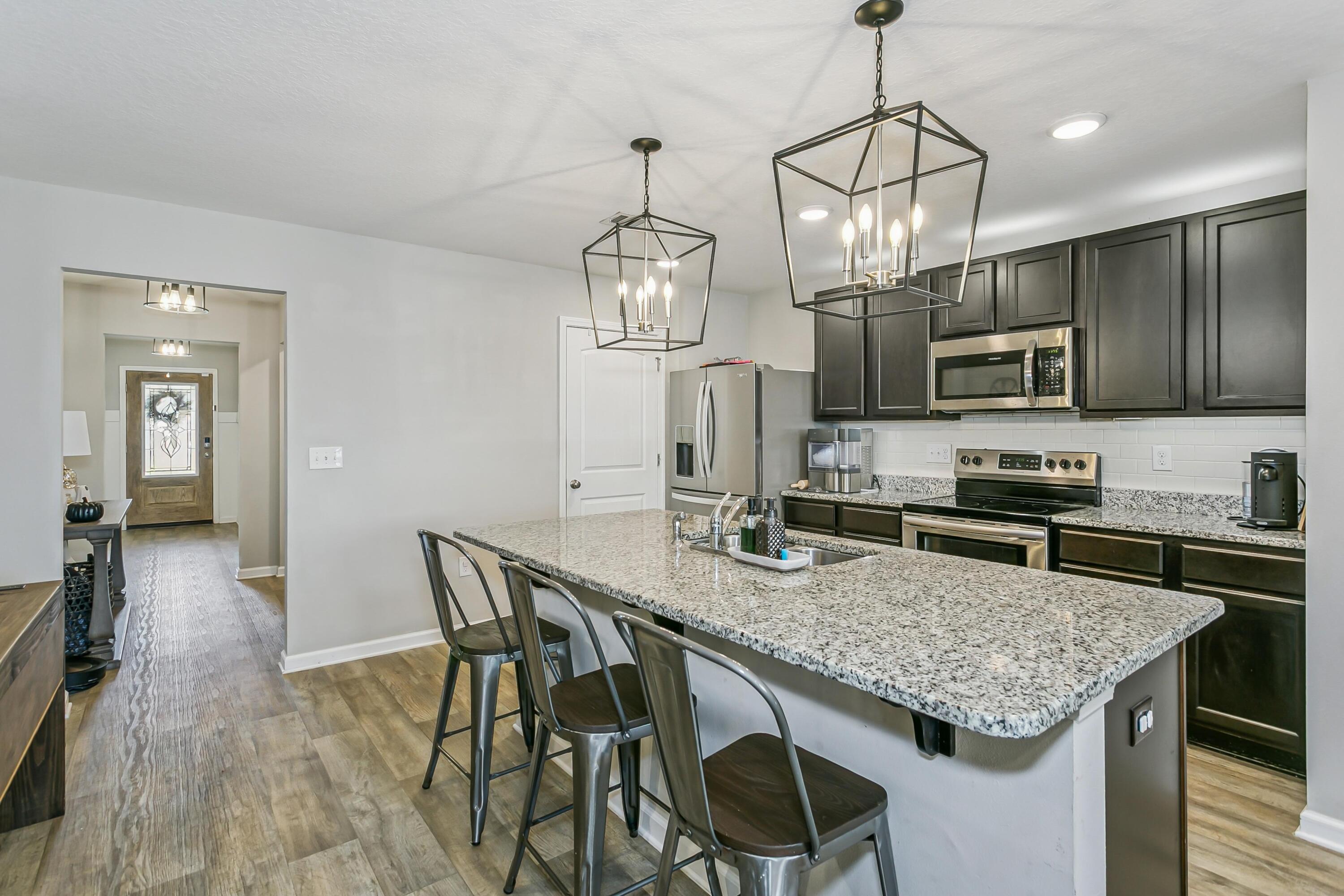936 Merganser Way Crestview, FL 32539 - Photo 11 of 39 a kitchen with stainless steel appliances granite countertop a kitchen island a stove a table and chairs