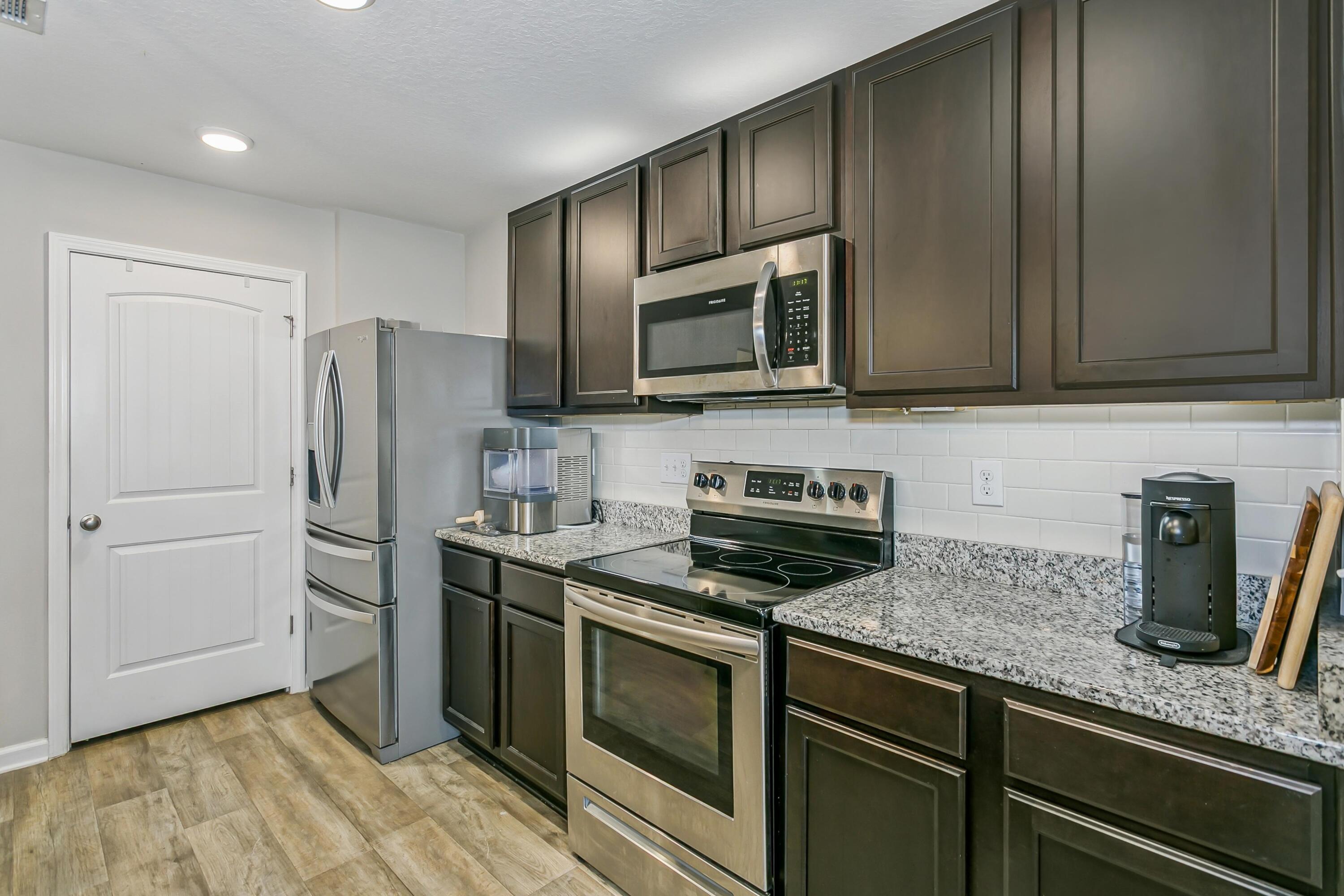 936 Merganser Way Crestview, FL 32539 - Photo 12 of 39 a kitchen with stainless steel appliances granite countertop a stove a microwave and a refrigerator