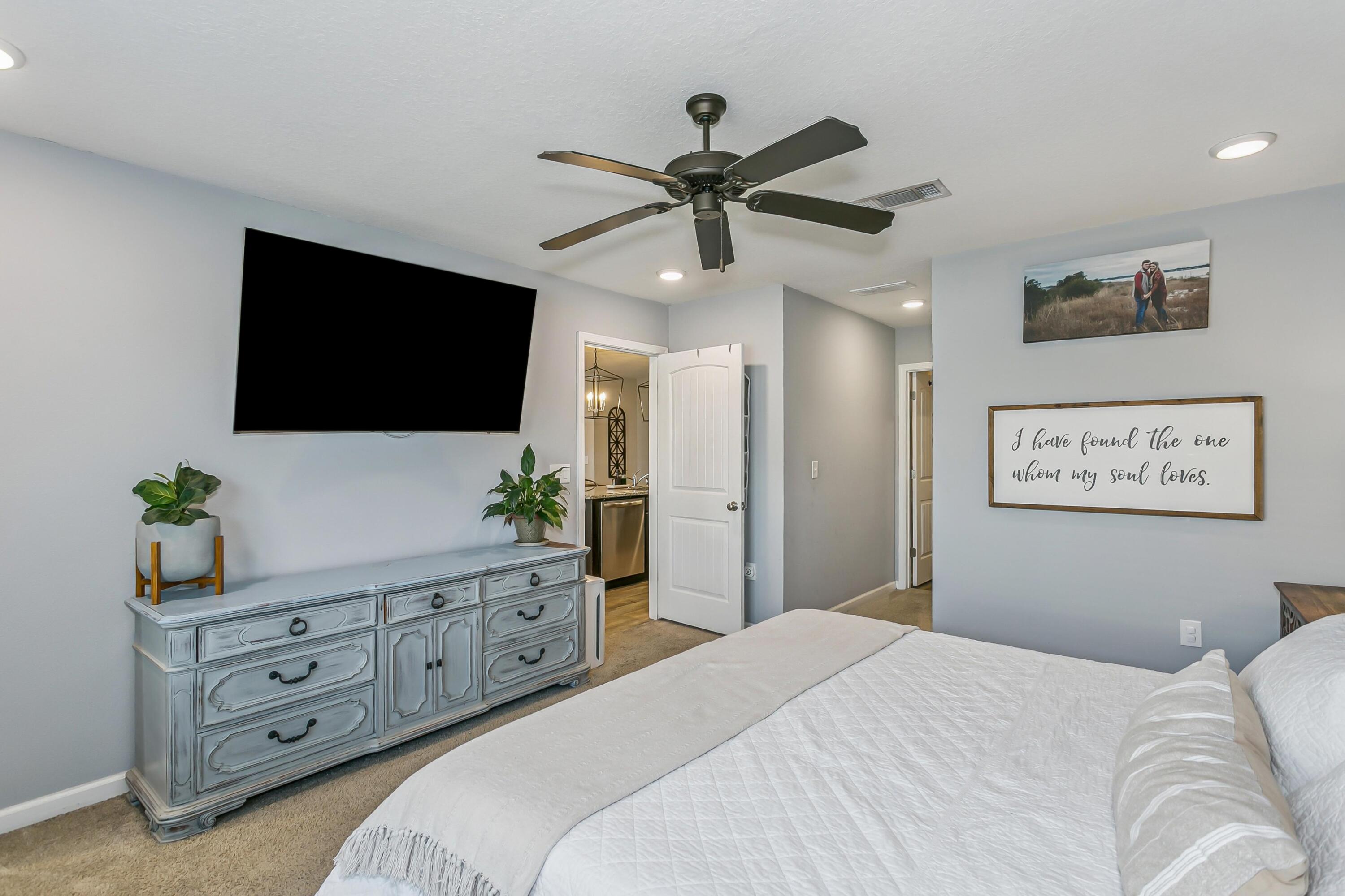 936 Merganser Way Crestview, FL 32539 - Photo 15 of 39 a bedroom with a bed a flat screen tv and a potted plant