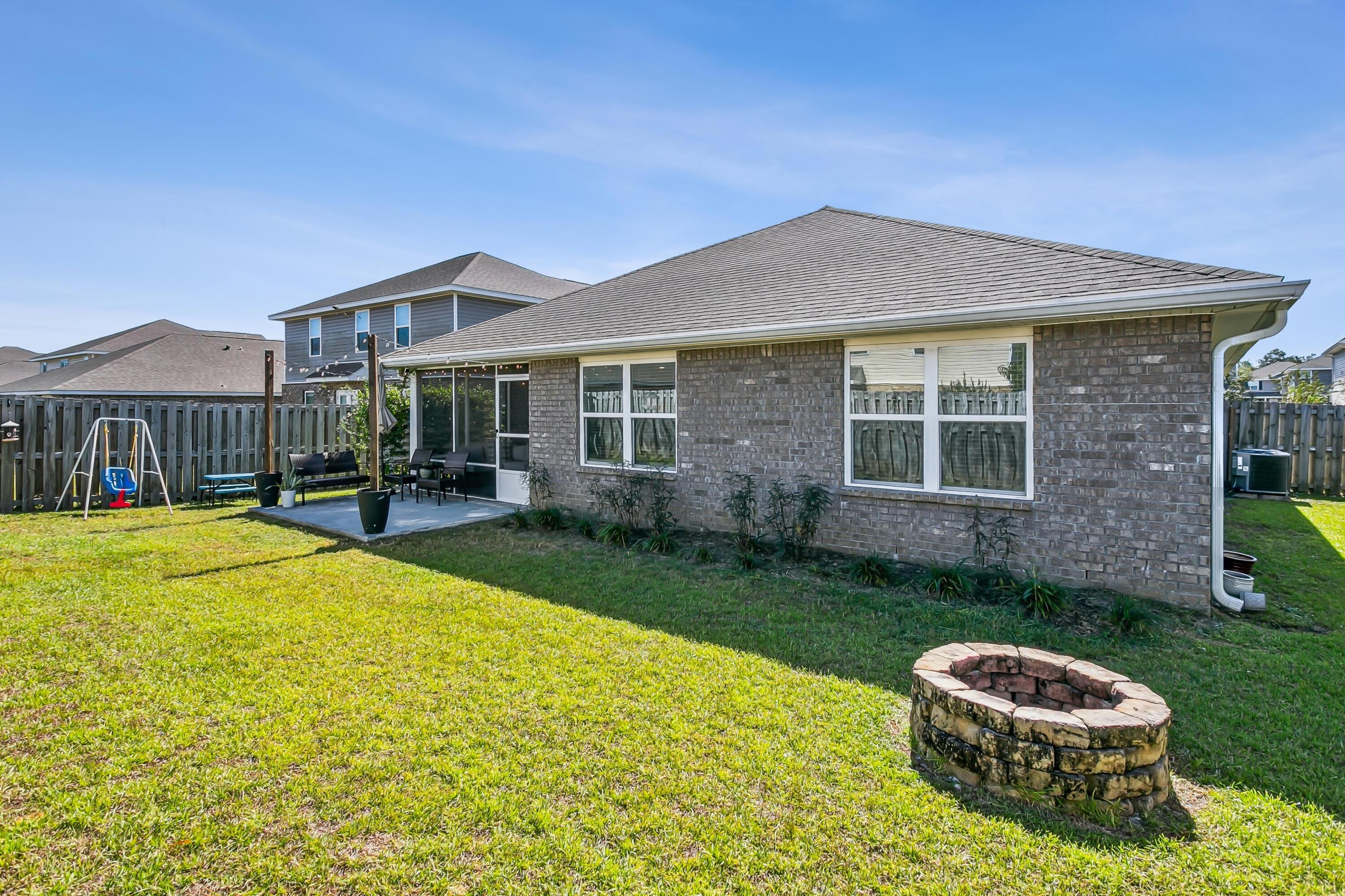936 Merganser Way Crestview, FL 32539 - Photo 32 of 39 a backyard of a house with a fountain table and chairs
