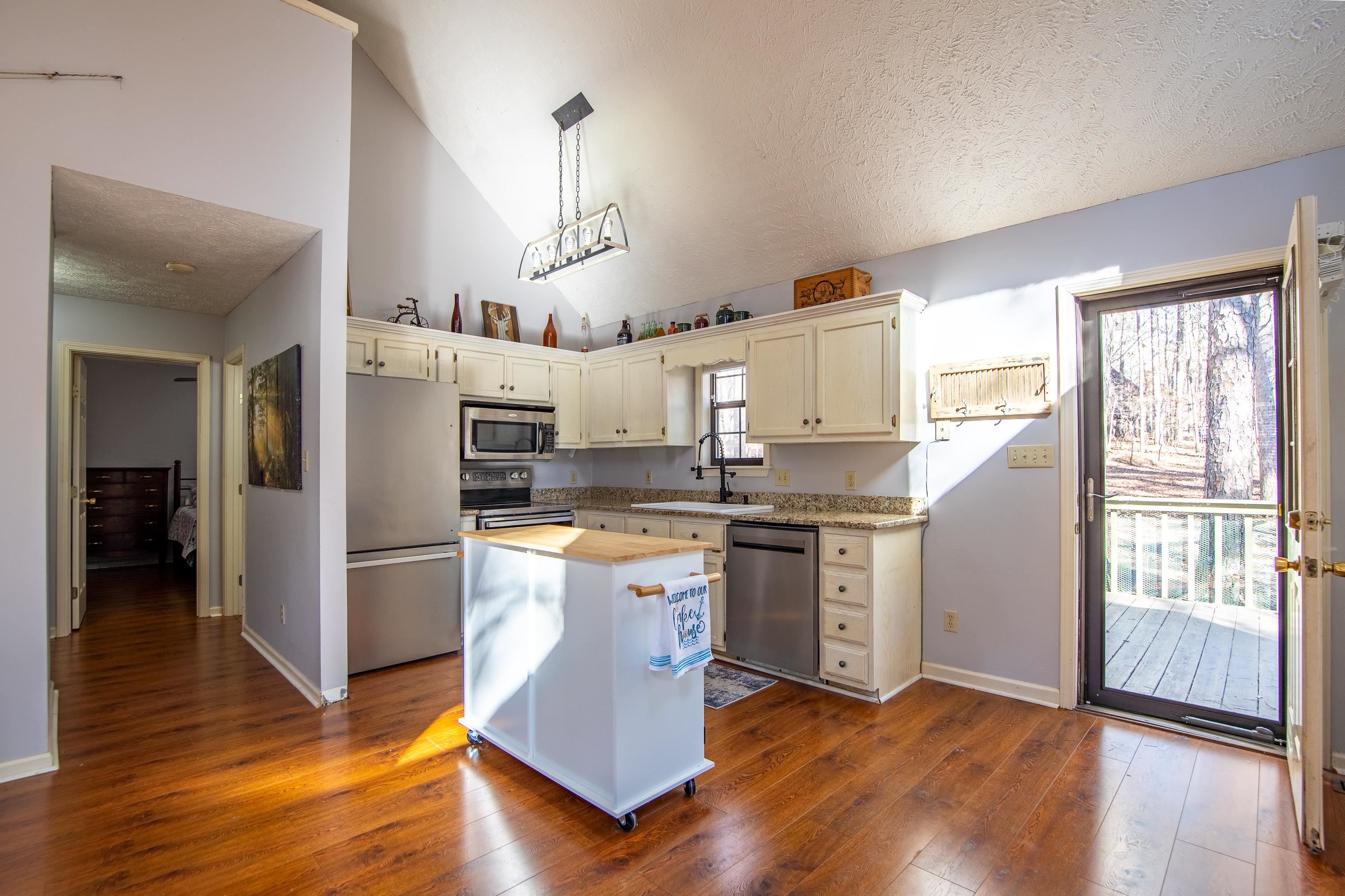315 Bryson Harbor Road Counce, TN 38326 - Photo 15 of 37 a kitchen with granite countertop a refrigerator and wooden floors