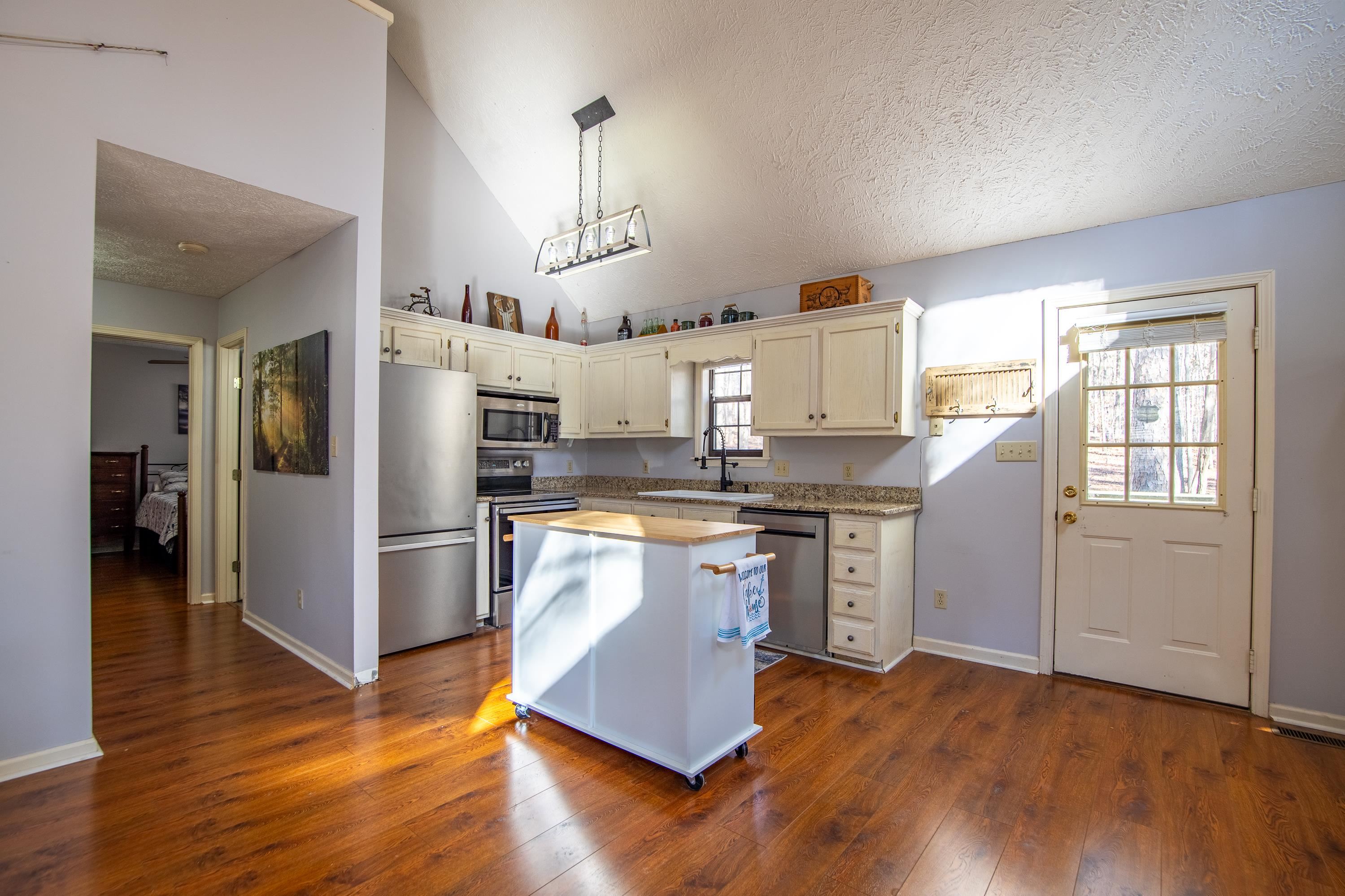 315 Bryson Harbor Road Counce, TN 38326 - Photo 20 of 37 a kitchen with stainless steel appliances granite countertop a refrigerator a sink dishwasher a stove and white countertops with wooden floor