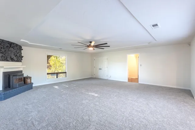 a view of a livingroom with a fireplace and window