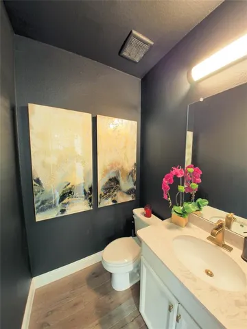 a bathroom with a sink vanity mirror and toilet
