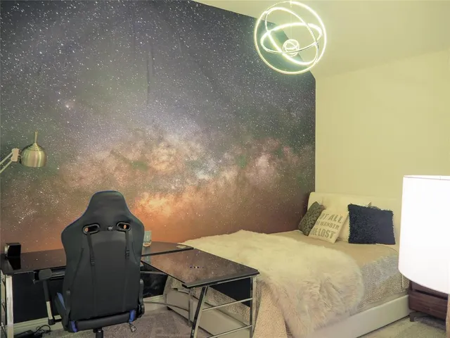 a bedroom with a bed and teddy bear on table