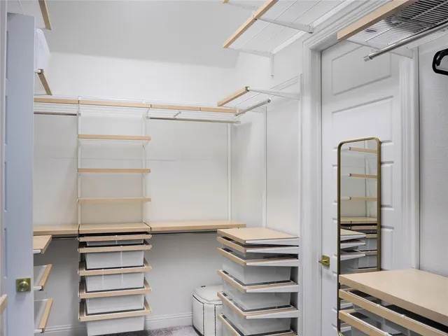 a view of walk in closet with empty racks