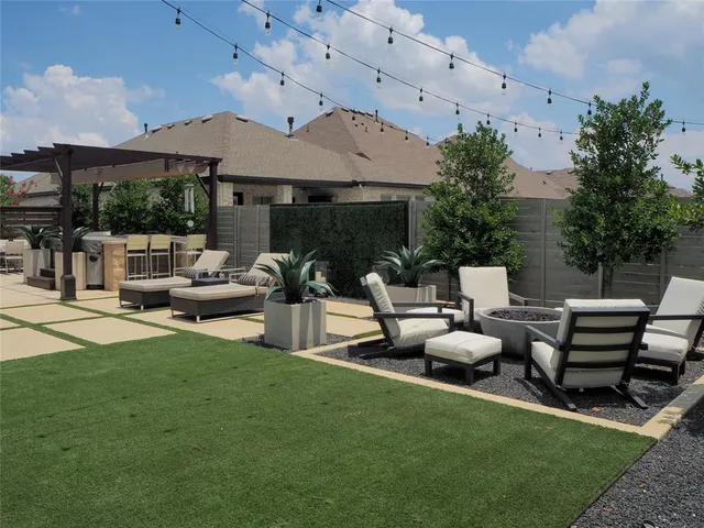 a view of a patio with table and chairs potted plants and a large tree