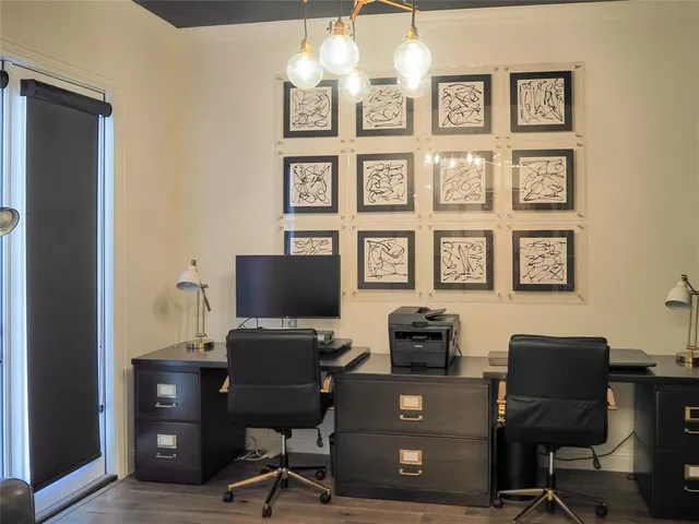 a view of a workspace with furniture and a window