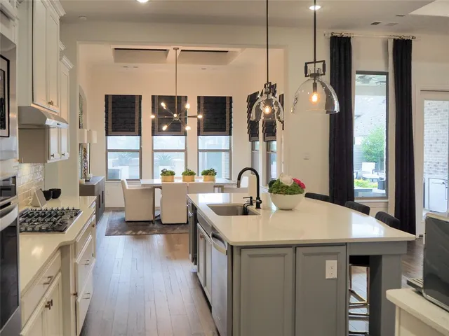 a kitchen with a sink a counter top space stainless steel appliances a large window and cabinets