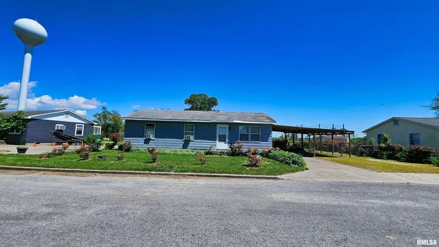 a front view of a house with a yard and potted plants