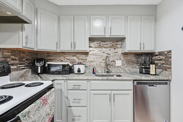 a kitchen with stainless steel appliances granite countertop a sink stove and cabinets