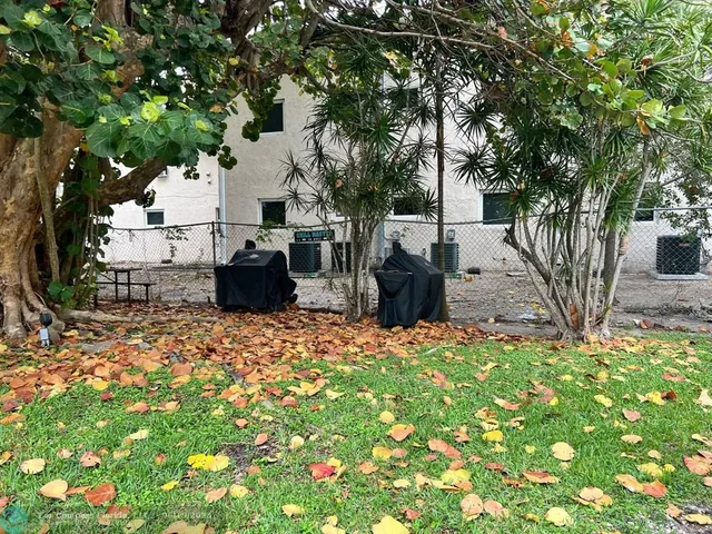 a backyard of a house with barbeque oven and outdoor seating