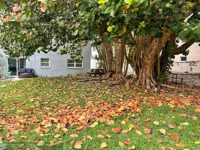 a view of a deck with furniture and a yard with wooden fence