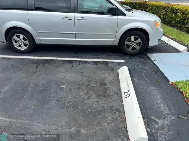 a view of a hallway with wooden floor and a large mirror