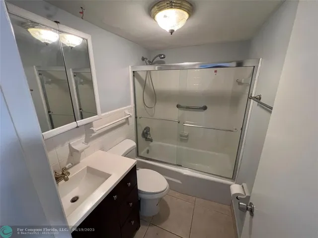 an empty room with mirror and entrance