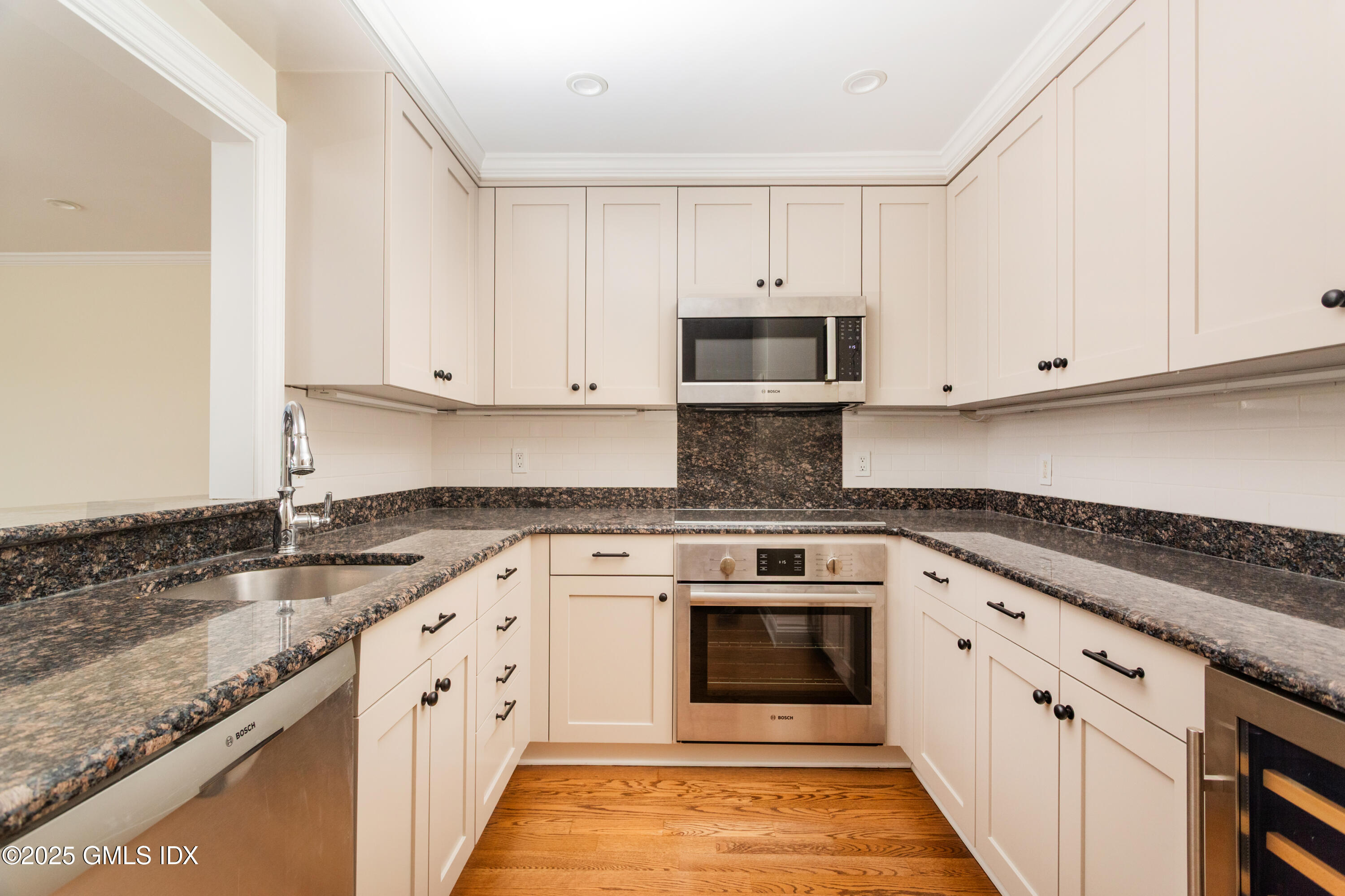 15 River Road, Unit 220 Cos Cob, CT 06807 - Photo 8 of 27 a kitchen with granite countertop white cabinets and stainless steel appliances