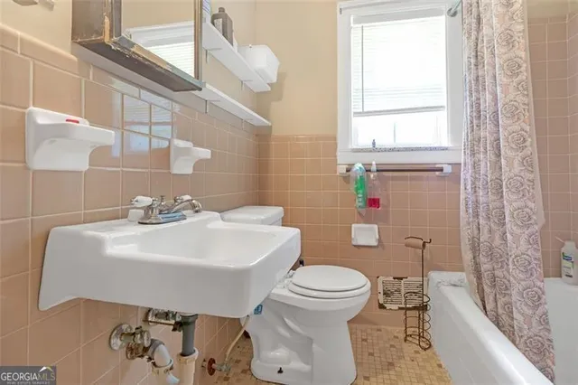 a white toilet sitting next to a bathroom sink