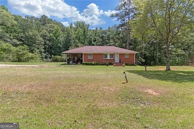 a view of a house with a yard and sitting area