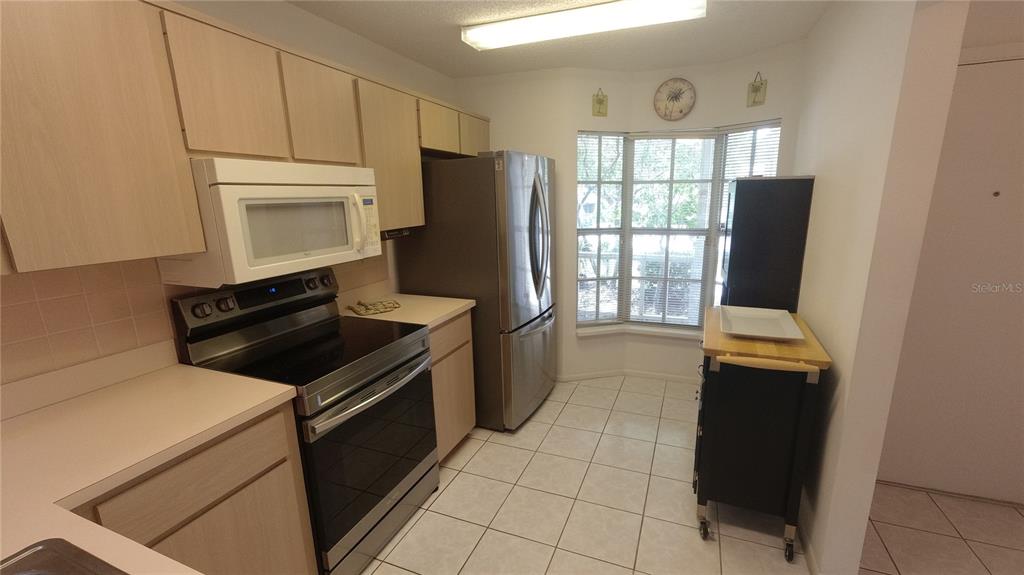 6421 Remus Drive New Port Richey, FL 34653 - Photo 5 of 25 a kitchen with a refrigerator and a stove