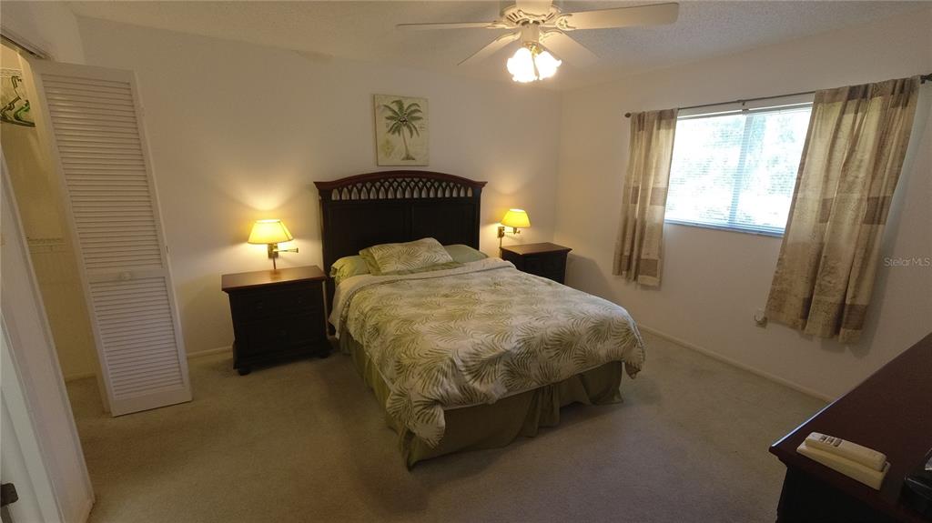 6421 Remus Drive New Port Richey, FL 34653 - Photo 8 of 25 a bedroom with a bed and a chandelier
