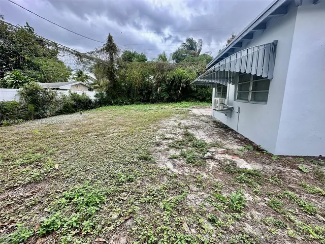 a view of backyard with potted plants and wooden fence