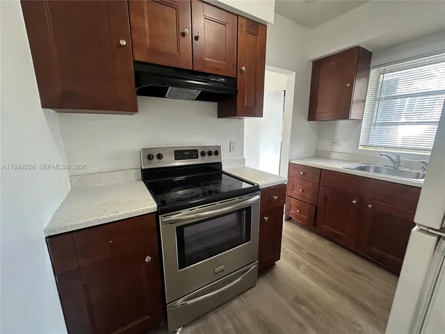 a view of a room with wooden floor and white walls
