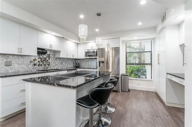 a kitchen with a stove a sink a refrigerator and wooden cabinets