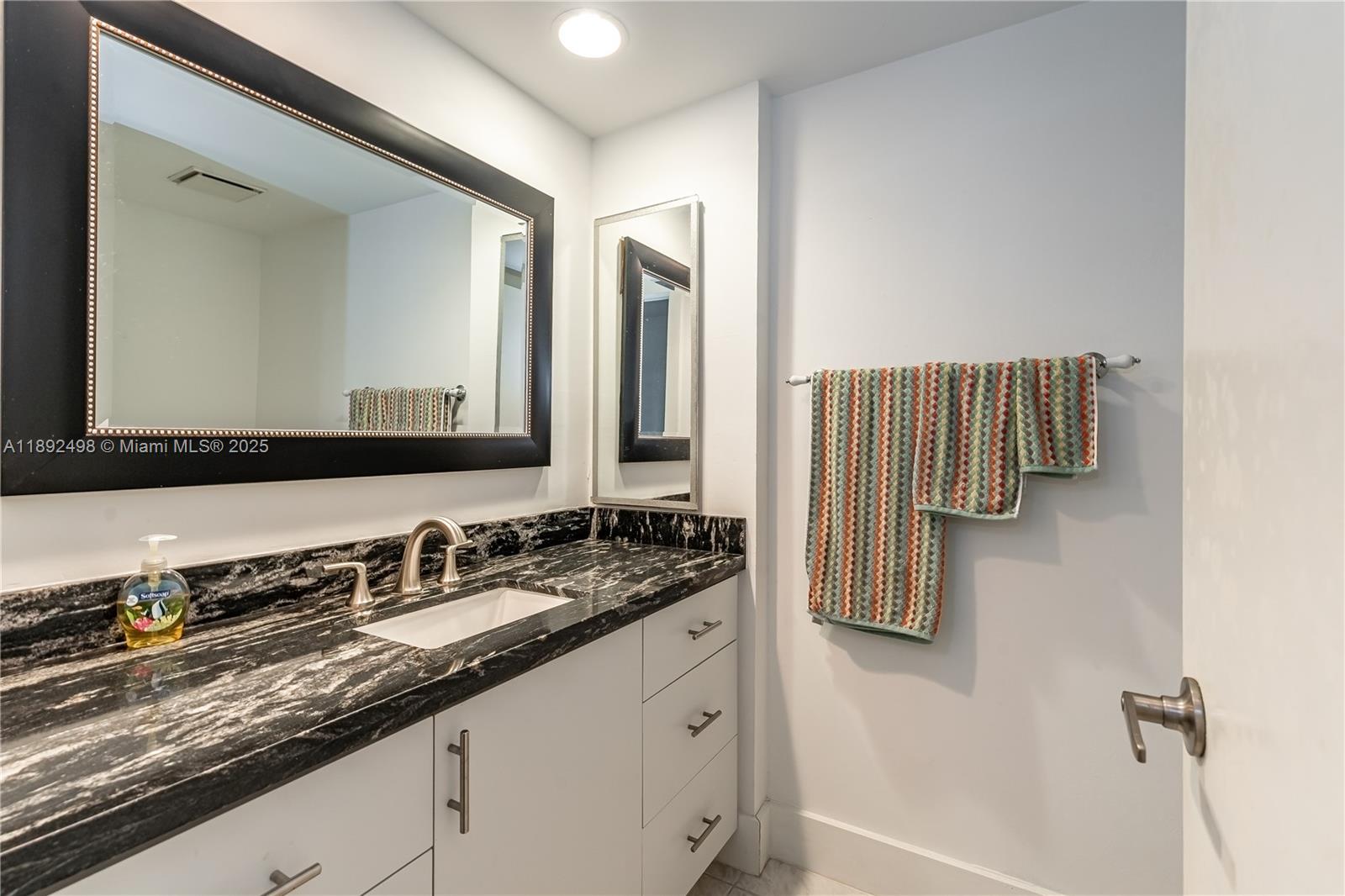 7300 Radice Court, Unit 109 Lauderhill, FL 33319 - Photo 23 of 35 a bathroom with a granite countertop sink and a mirror