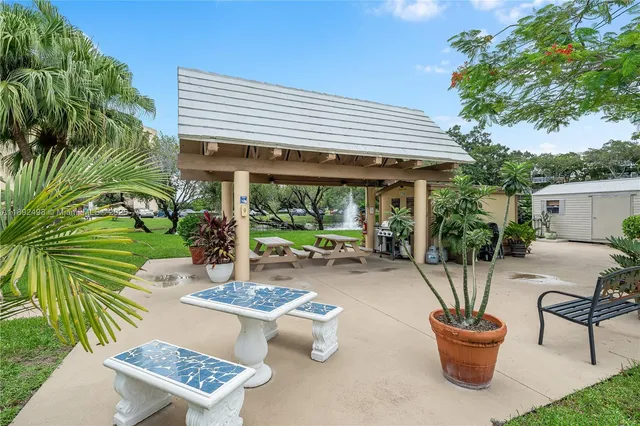 a view of a patio with table and chairs potted plants and palm tree
