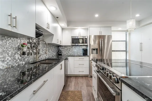 a kitchen with stainless steel appliances granite countertop a sink stove and refrigerator