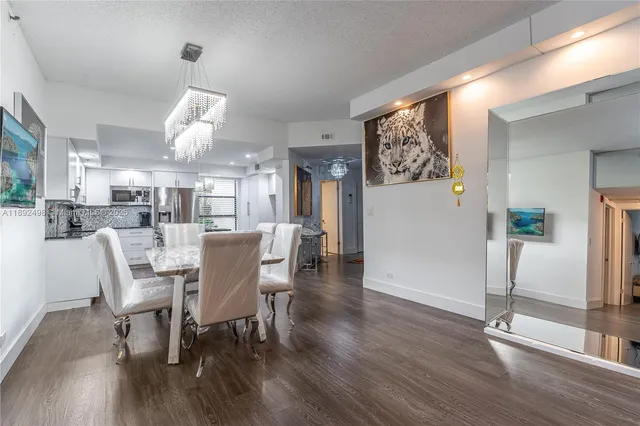 a dining room with furniture a chandelier and wooden floor