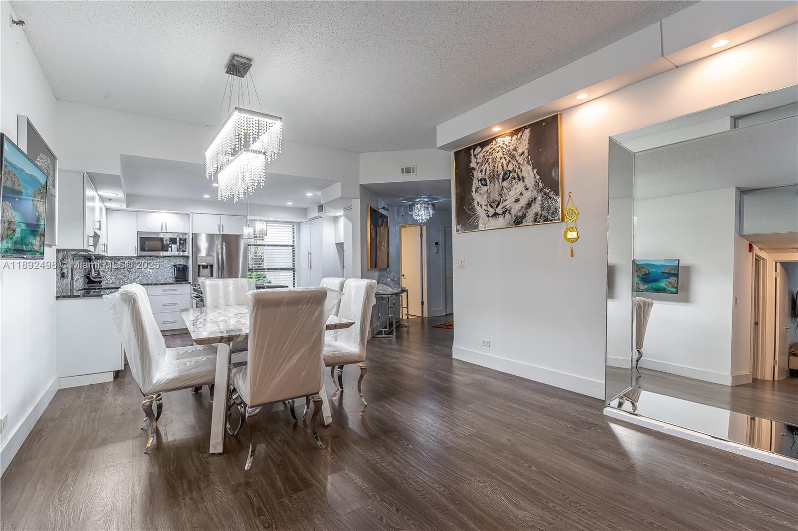 7300 Radice Court, Unit 109 Lauderhill, FL 33319 - Photo 7 of 35 a dining room with furniture a chandelier and wooden floor