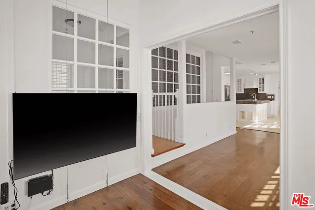 a view of a living room with wooden floor and stairs