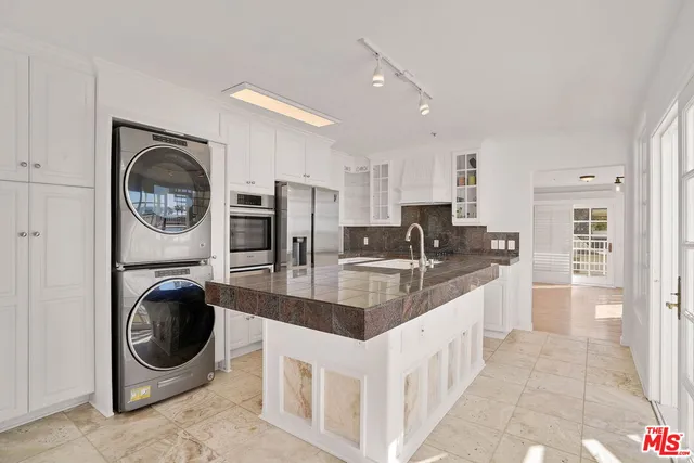a kitchen with stainless steel appliances granite countertop a white stove top and cabinets